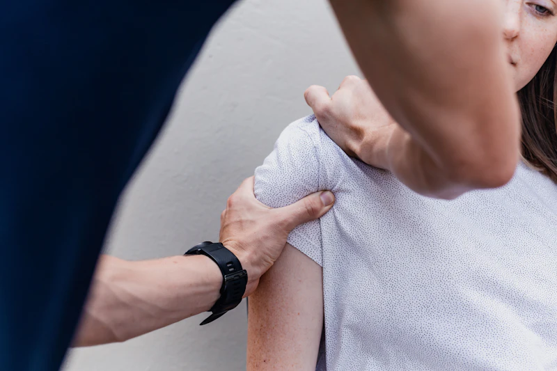 Fizjoterapeuta bada ruchomość barku pacjentki